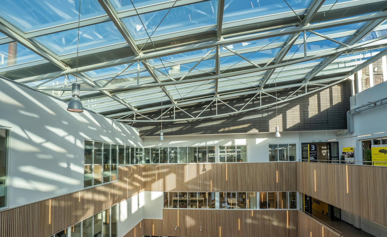Indoor air quality testing — modern multi-story commercial atrium with steel-and-glass ceiling, large commercial space where IAQ matters